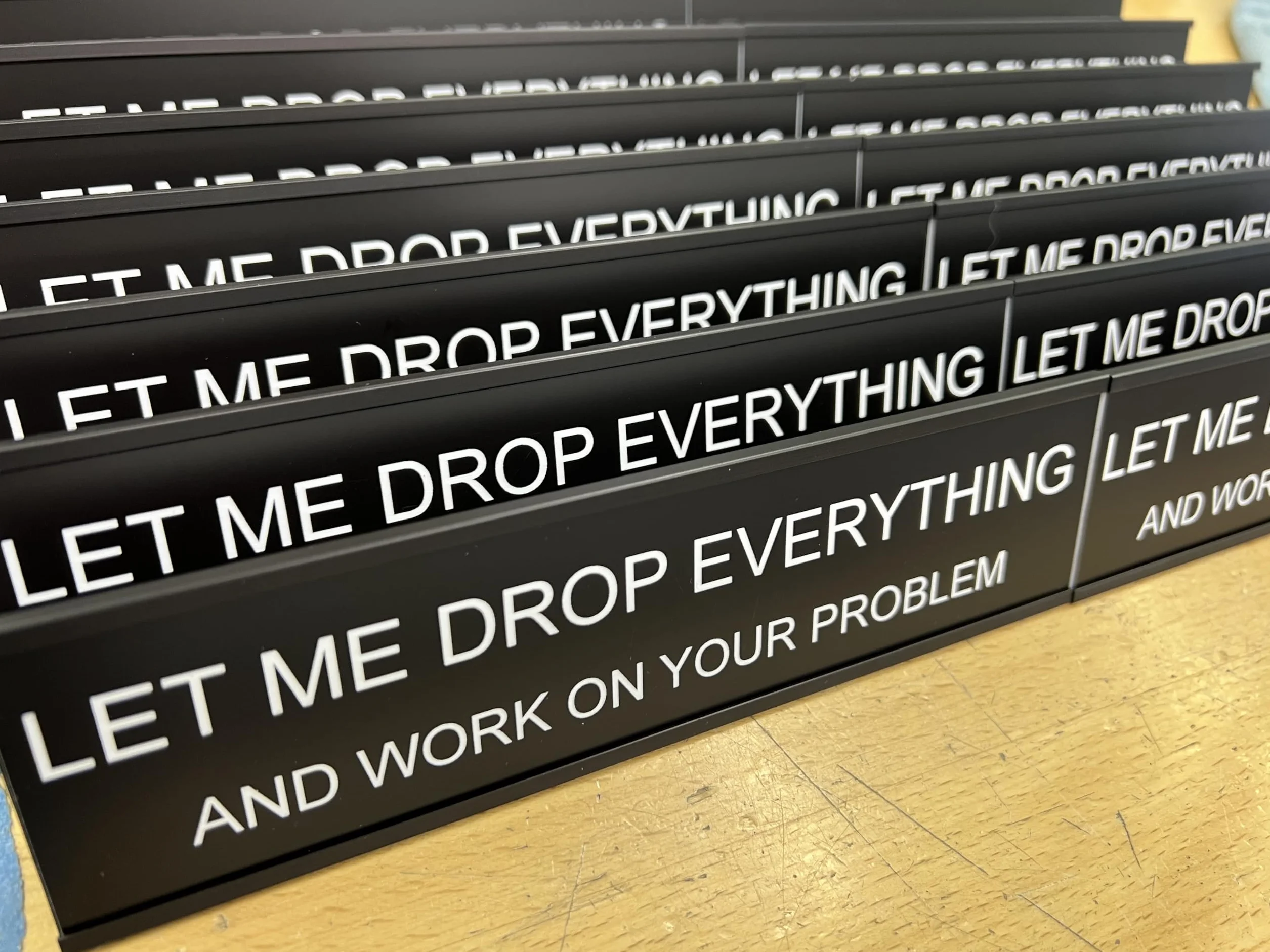 Let Me Drop Everything and Work On Your Problem - Lotsa Laughs zabawna dekoracja biurka, zabawne dekoracje biurowe firmy Griffco Supply (czarny z białym tekstem)